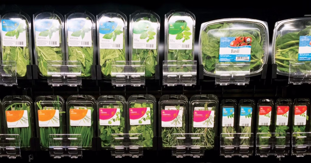 Fresh herbs in pusher tray systems at a grocery store