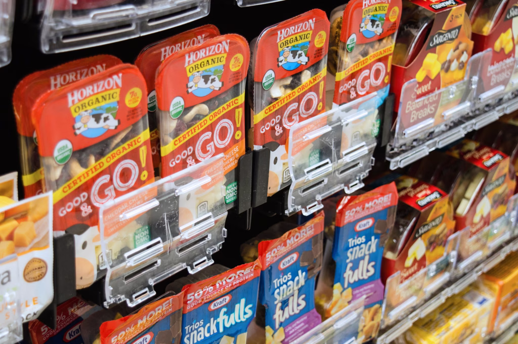 Grab-and-go snack packs arranged on a slanted shelf.